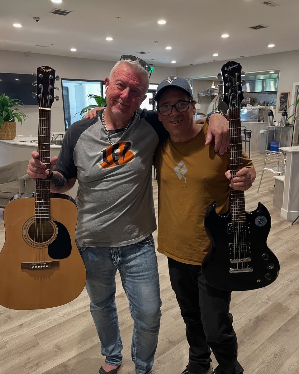 two men holding guitars