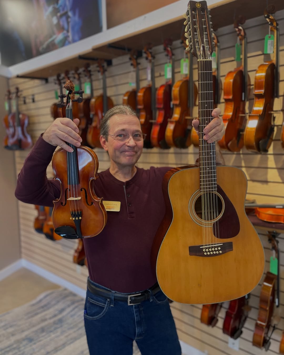 man holding a guitar and violin
