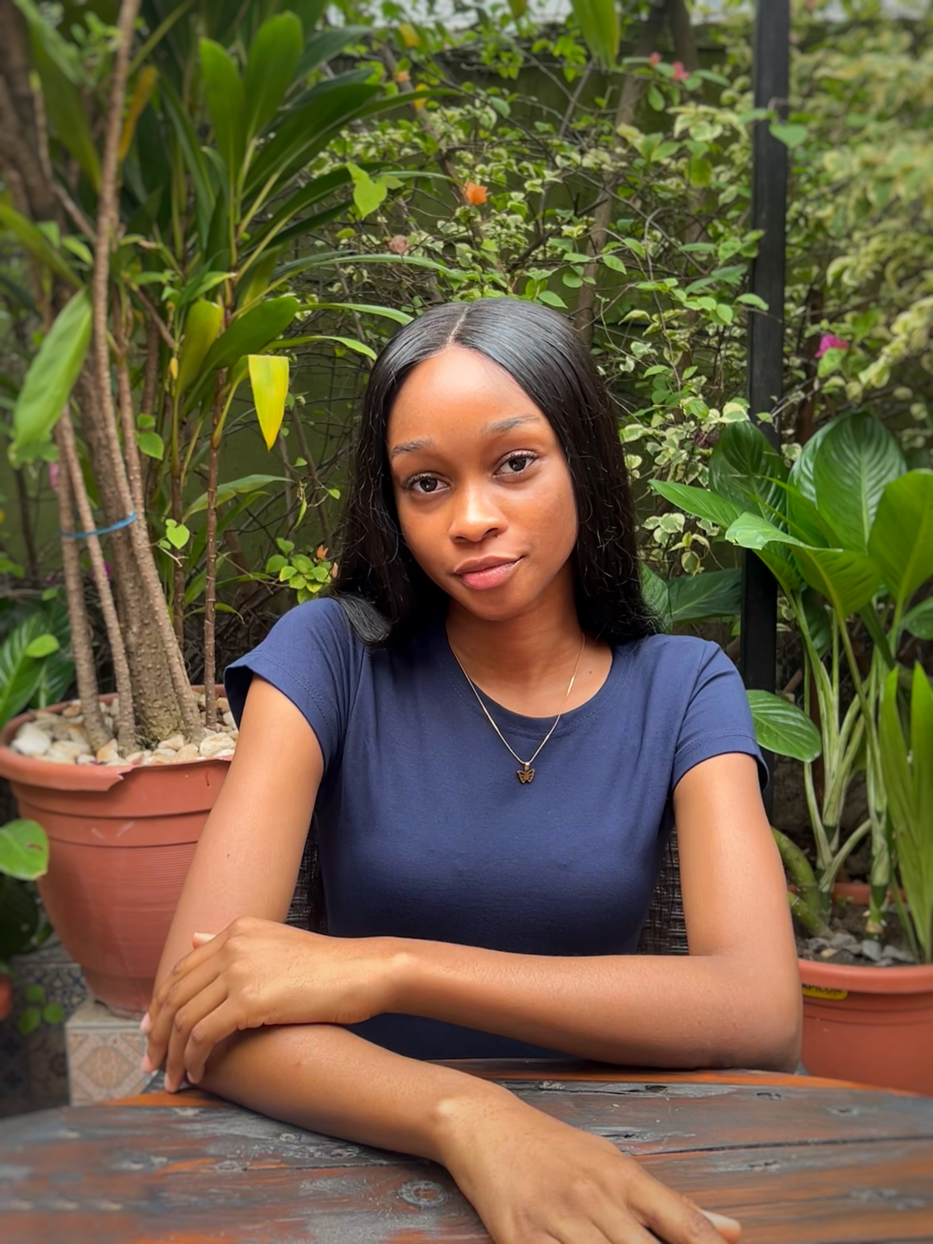 Chella sitting beautifully across a table, with a plant adorned background