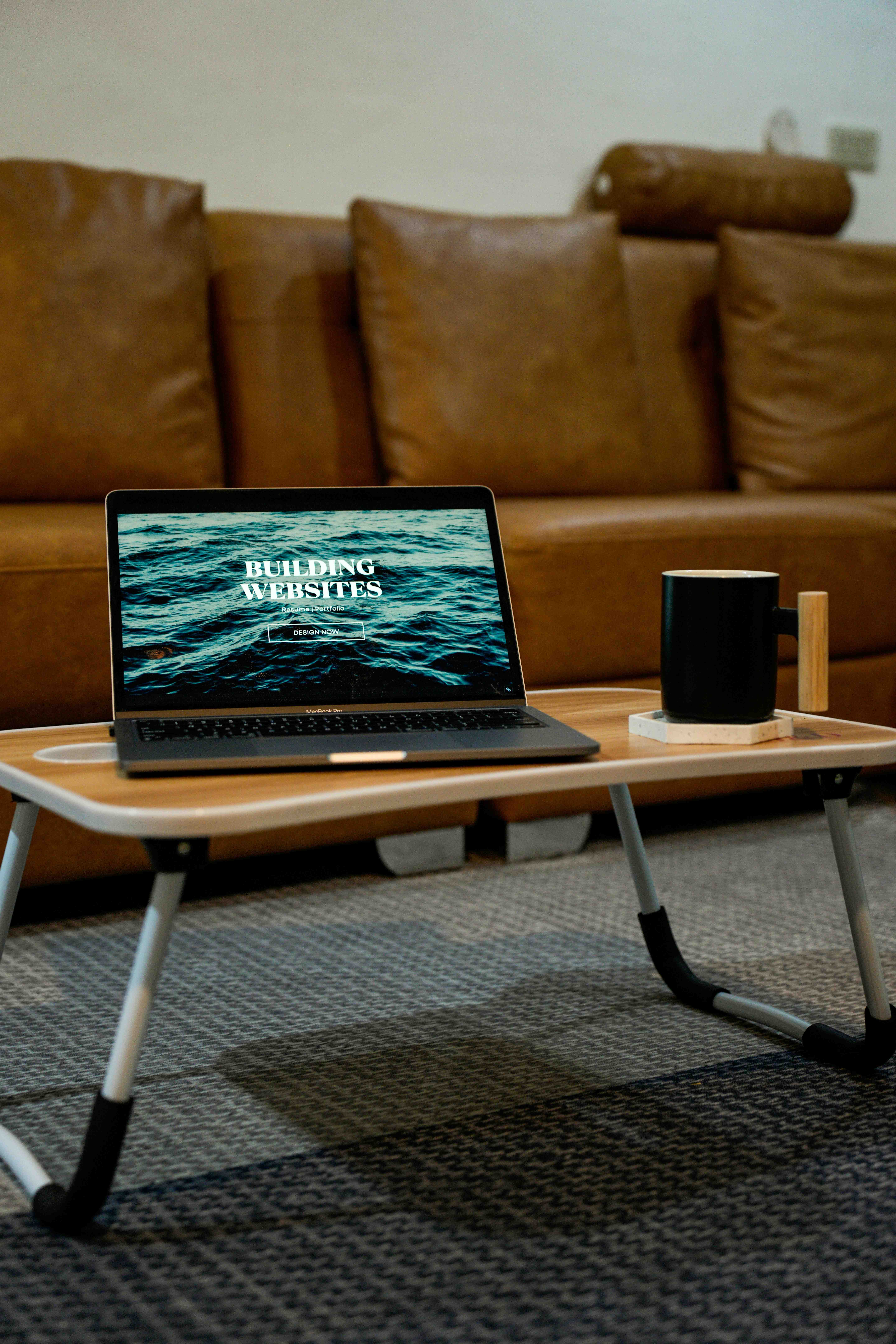 laptop computer on wood desk next to mug
