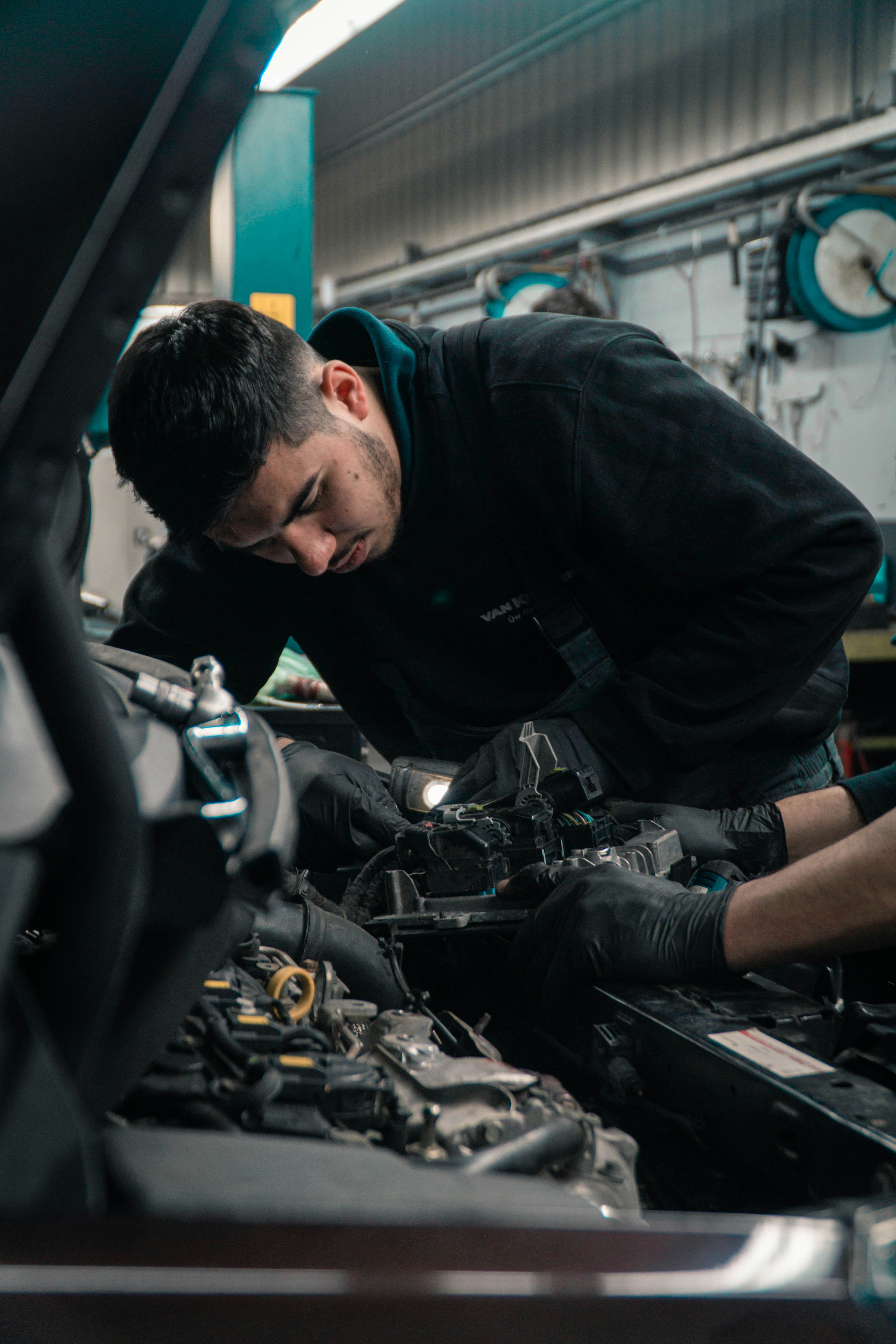 People working on car in auto shop.