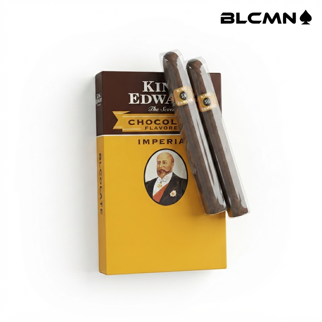 Studio product photograph on a clean white background showcasing an upright box of King Edward Imperial Chocolate Flavored cigars (Pack of 5), with two individually wrapped cigars placed diagonally across the front of the packaging. The black typography logo "BLCMN♠️" is placed in the top right corner.