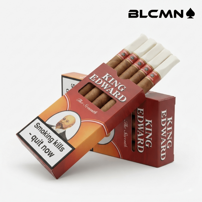 A high-resolution, studio 3D product photograph on a clean white background showcasing an open red and yellow retail pack of King Edward Tip Cigarillos displaying several tipped cigarillos inside, next to a closed retail pack and an individual tipped cigarillo laid out by its side. The black typography logo "BLCMN♠️" is placed in the top right corner.