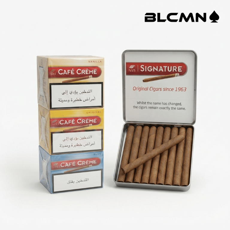 A high-resolution, studio 3D product photograph on a clean white background featuring a stacked assortment of Cafe Creme master packaging blocks in Vanilla, Original, and Blue variants next to an open metal tin displaying ten miniature cigarillos inside alongside a single cigarillo resting on the edge. The black typography logo "BLCMN♠️" is placed in the top right corner.